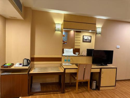 a hotel room with a desk with a television at Hotel the Plaza in Hyderabad