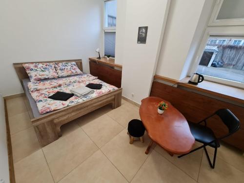 a bedroom with a bed and a table and a chair at Fantastic-Inn Warszawa - Czackiego in Warsaw