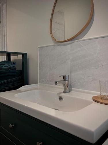 a bathroom with a sink and a mirror and a sink at L'Escale de la Râperie, logement 3 in Tincourt-Boucly