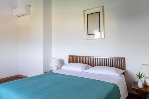 a bedroom with a large bed with a blue blanket at Podere Caprarecce Trilocale 6 in Talamone