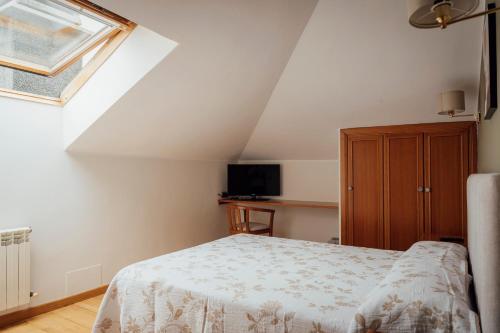 a small bedroom with a bed and a window at Hotel San Jorge in Nueva de Llanes