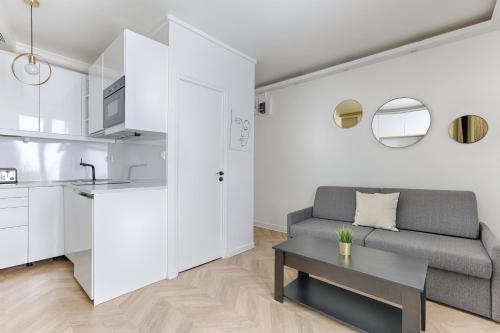 un salon avec un canapé et une table dans l'établissement So Ouest Courcelles Magnifique Studio, à Levallois-Perret