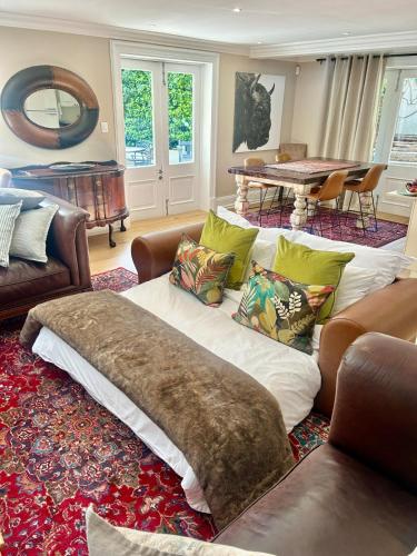 una sala de estar con un sofá y una mesa en French Manor 1, en Stellenbosch
