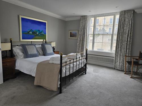 a bedroom with a bed and a large window at Vintner Townhouse Artisan Quarter Bath in Bath