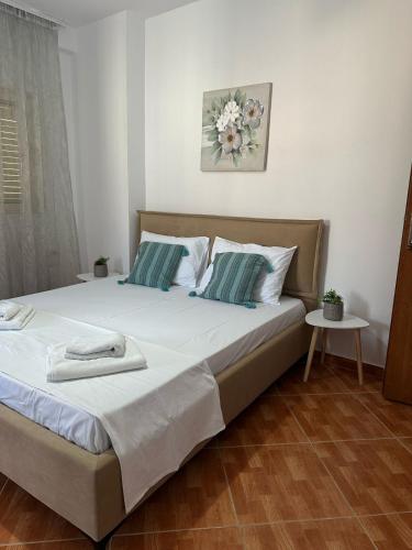 a bedroom with a large bed with white and blue pillows at Himara Apartaments in Himare