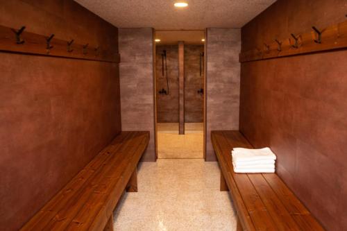 a room with two wooden benches and a walk in shower at Glacier World - Hoffell Guesthouse in Hoffell