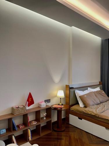 a bedroom with a bed and a table with a lamp at The Nest High-Floor Studio with City View in Ðông Khê