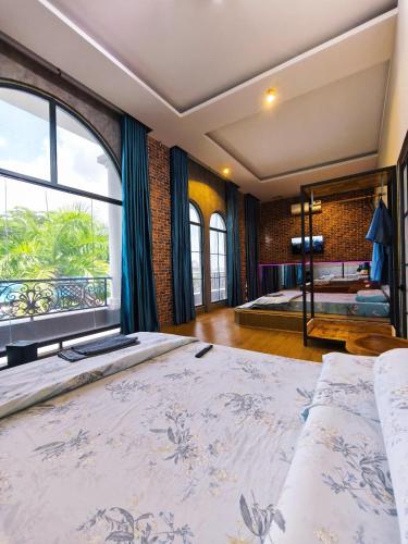 a bedroom with a large bed and a large window at Long Homestay Mỹ Hạnh - Hotels in Ðức Hòa