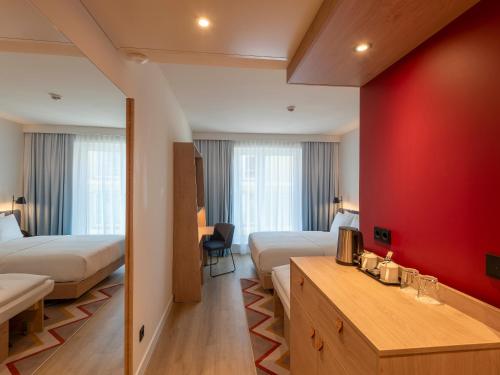 a hotel room with two beds and a red wall at Hampton By Hilton Dresden City Centre in Dresden