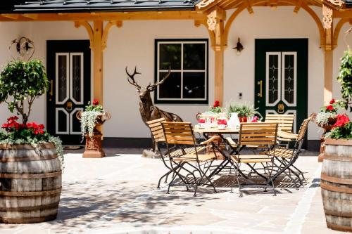 a patio with a table and chairs and a deer statue at Lippingergut - Urlaub im Wolfgangseetal - Ferienwohnung EG in St. Wolfgang