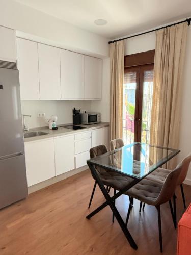 a kitchen with a glass table and chairs in a room at Apartamentos Molinos in Constantina