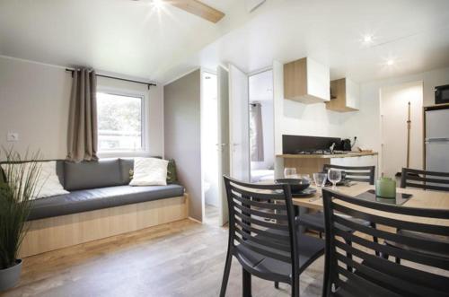 a living room with a couch and a dining table at Camping Le Florenville in Florenville