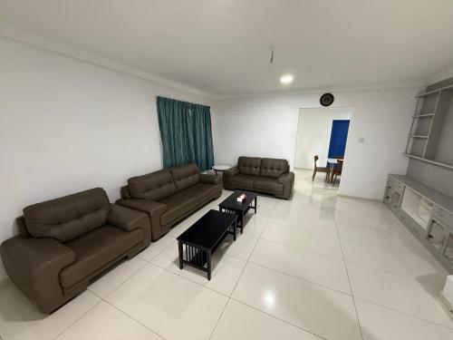 a living room with two couches and a table at Pretty's home in Ranau