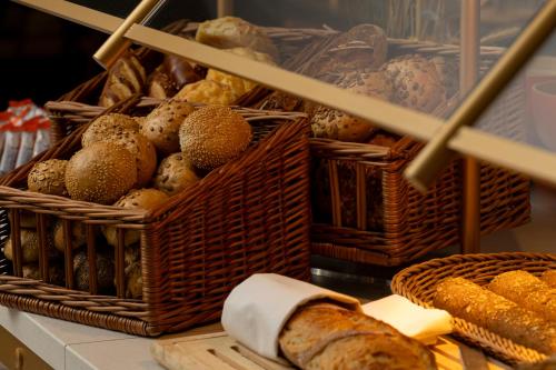 a bunch of baskets filled with different types of bread at Hilton Düsseldorf in Düsseldorf