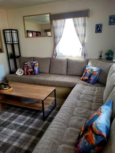 a living room with a couch and a coffee table at 61 St Andrew's 3 bedroom Cozy Caravan near Edinburgh Seton Sands Holiday Village in Port Seton