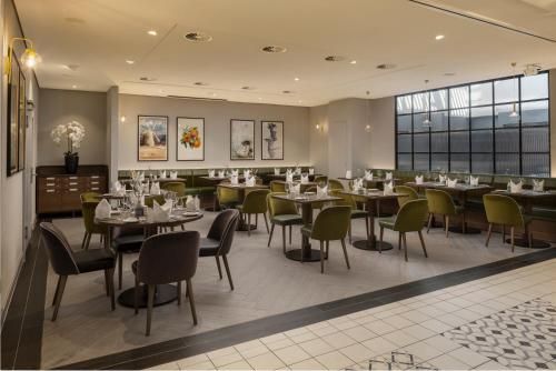 a restaurant with tables and chairs and a large window at Hilton Düsseldorf in Düsseldorf