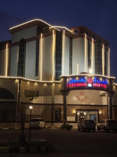 a hotel with cars parked outside of it at night at فندق زهوان للضيافة السياحي in Al Buwaţah
