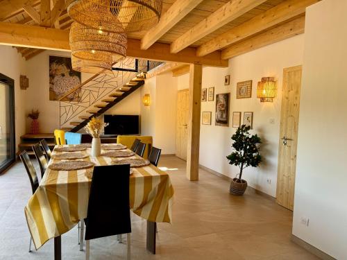 Un comedor con mesa y sillas en Le domaine d'Isa Elor et Sela, en Vienville