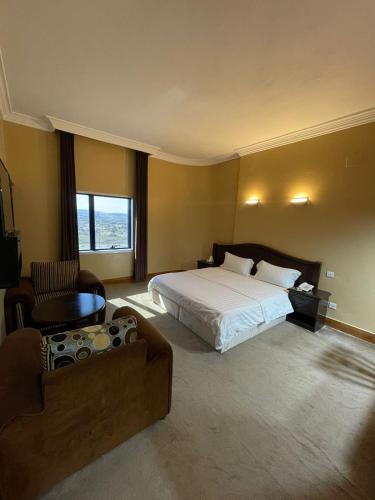 a hotel room with a bed and a couch at فندق زهوان للضيافة السياحي in Al Buwaţah