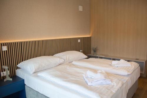 two beds in a room with towels on them at Gardinn Apartments - Hotel Service and Free Parking in Bratislava