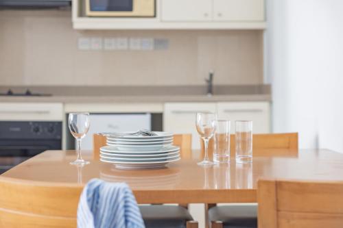 a table with plates and wine glasses on it at Louis Althea Beach in Protaras
