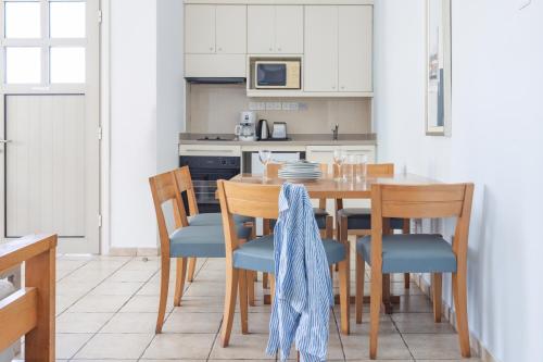 a kitchen with a wooden table and chairs at Louis Althea Beach in Protaras