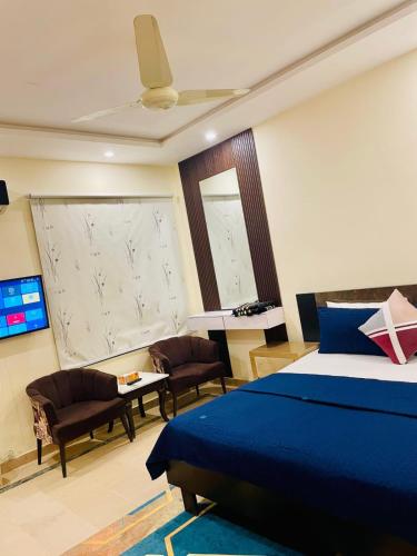 a bedroom with a blue bed and a table and chairs at Dream Lodge House in Islamabad