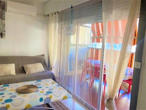 un salon avec un canapé et une fenêtre dans l'établissement Grand Studio Nice proche plages et Promenade des Anglais, à Nice