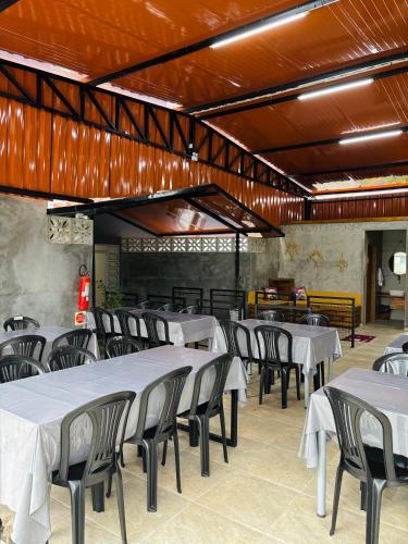 a dining room with white tables and chairs at Hotel São Francisco in São Francisco do Sul