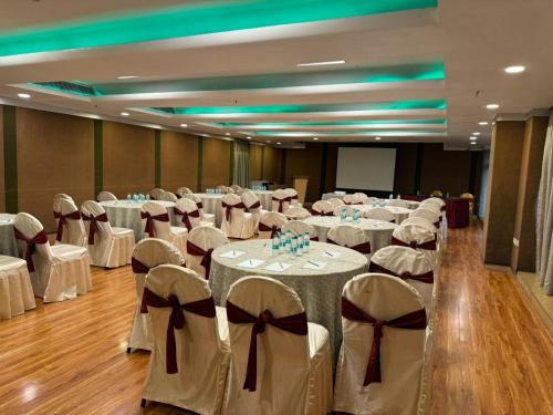 a banquet hall with white tables and chairs with bows at Hotel the Plaza in Hyderabad