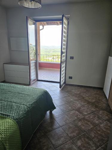 a bedroom with a bed and a door to a balcony at A casa di Thelma in Barolo