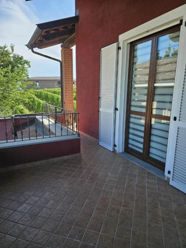 a balcony of a house with white doors at A casa di Thelma in Barolo