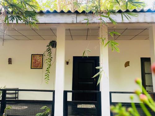 a front door of a house with a black door at Zensigiri Ayurveda Wellness Homestay in Sigiriya