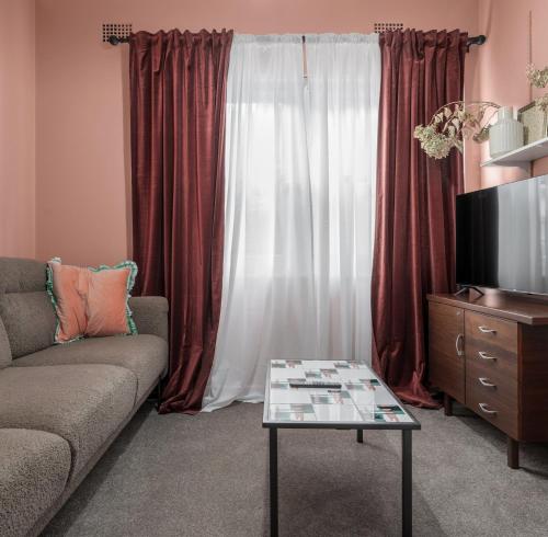 a living room with a couch and a tv at Ideal Location, 4 Beds, Mid-Century Home in Orange