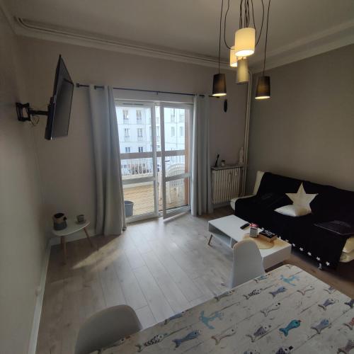 un salon avec un canapé et une table dans l'établissement Appartement T2 avec terrasse Luchon, à Luchon