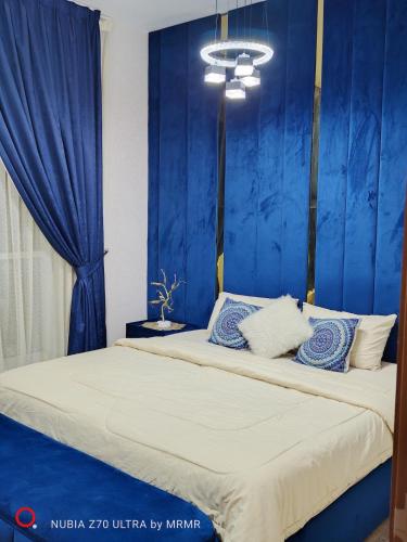 a bedroom with a bed with blue walls at Two bedrooms in Ajman, Oasis Towers in Ajman 