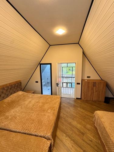 a large room with two beds and a door at AFrame Gabala Azerbaijan FF in Gabala