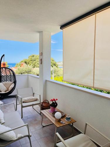a room with a large window with a table and chairs at Sea View Beachfront Apartment Maslina in Omiš