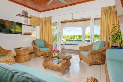 Grand'Anse PraslinにあるOcean Villaのソファと椅子とテーブルのあるリビングルーム