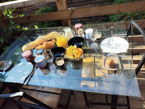 een glazen tafel met ontbijtproducten en drankjes erop bij La Pigoussette in Valensole
