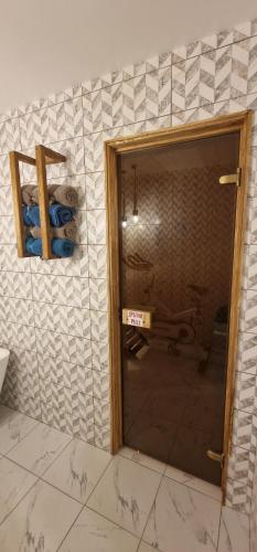 a bathroom with a door and a tile wall at Katerina Boutique Apartment in Bansko