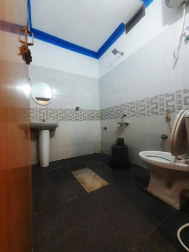 a bathroom with a toilet and a sink at Coorg Relax Home in Madikeri
