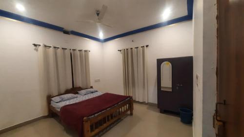 1 dormitorio con 1 cama y techo azul en Coorg Relax Home, en Madikeri