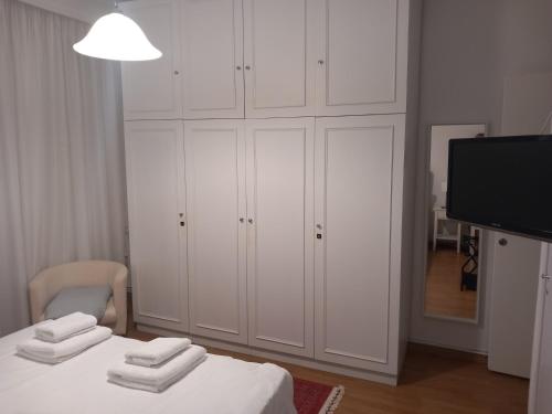 a white bedroom with white cabinets and a television at Απολαύστε τη διαμονή σας στις Σέρρες in Serres