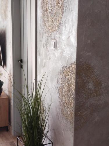 a wall with a door with a plant next to it at Apartament Kossaka in Elblag