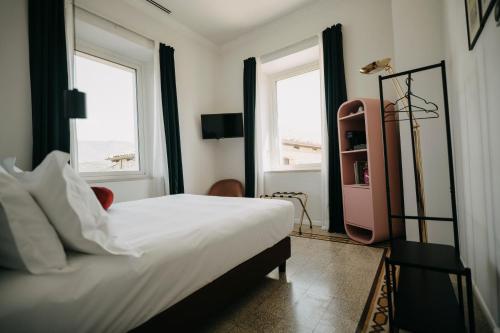 a bedroom with a large bed and two windows at Casa Qafiz 