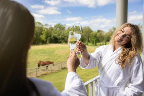 a woman holding up a glass of white wine at voco The Club - Dublin Gateway by IHG in Naas
