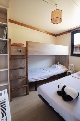 a bedroom with two bunk beds and a book shelf at Camping Le Florenville in Florenville
