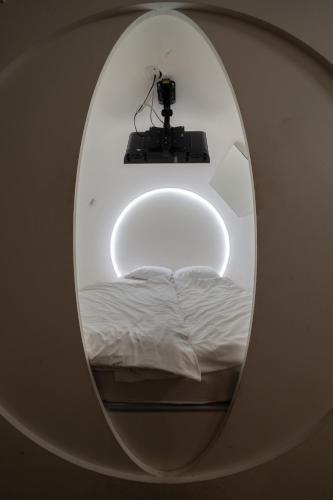a room with a round mirror with a bed and a camera at Wellness Hostel Central in Prague