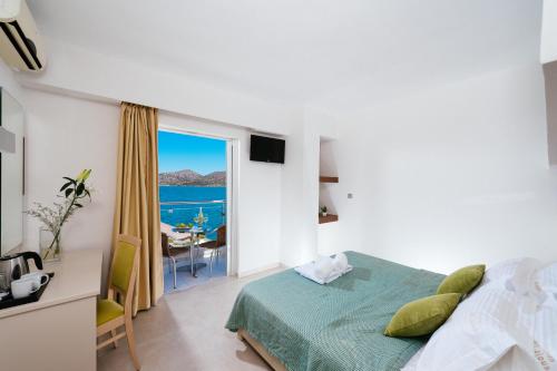 a bedroom with a bed and a view of the ocean at Elounda Akti Olous (Adults Only) in Elounda